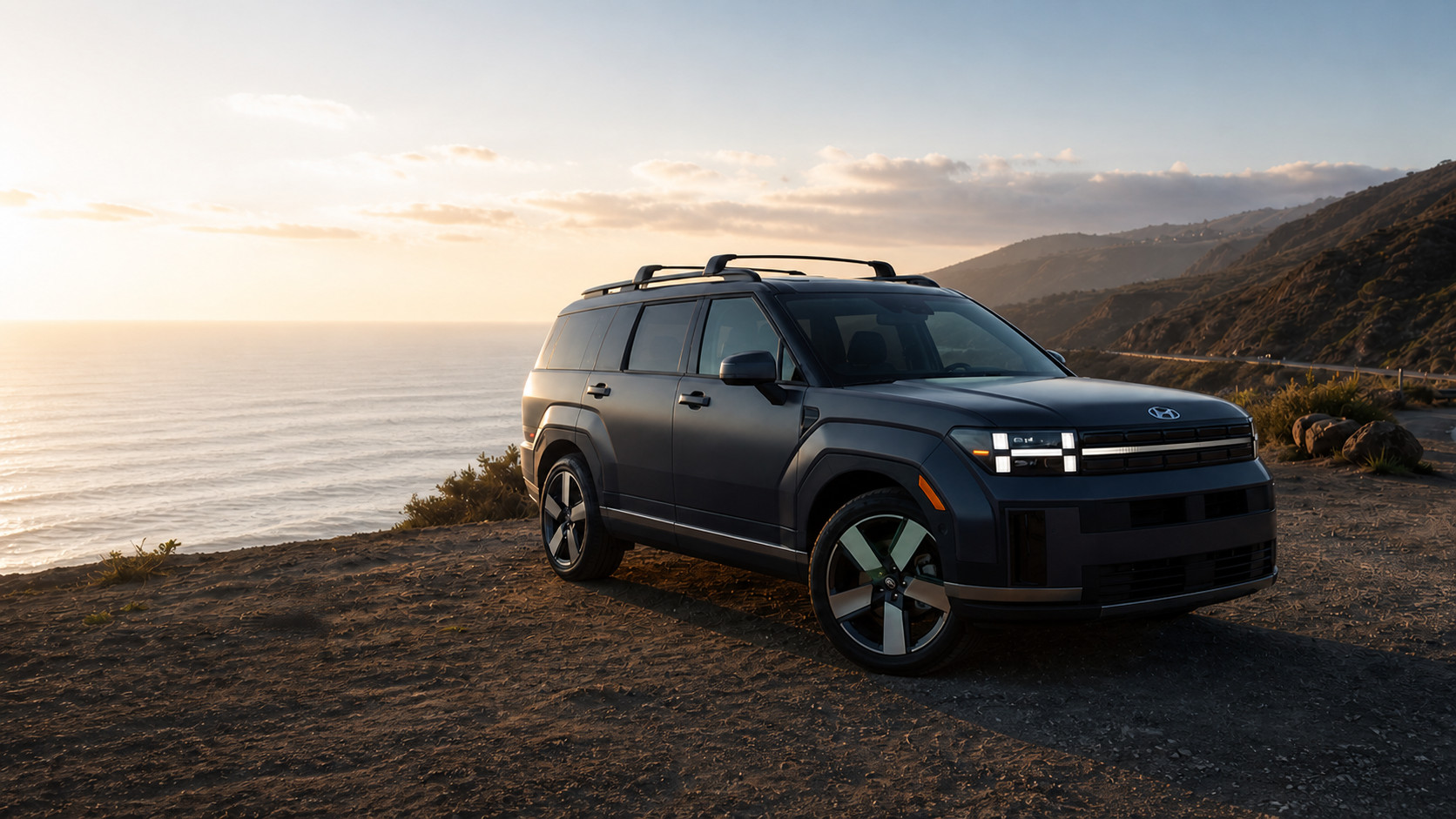A dark Santa Fe parked on a bluff above the Pacific at sunset
